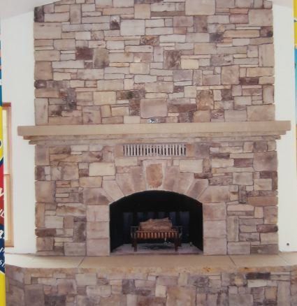 A picture of a stone fireplace with a brick wall