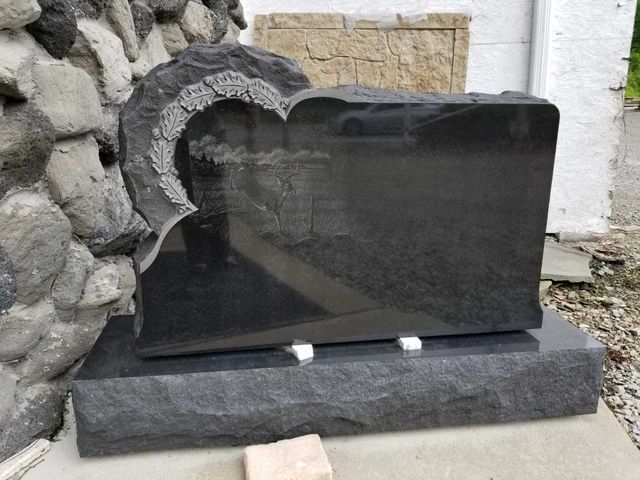 A black gravestone with a heart carved into it