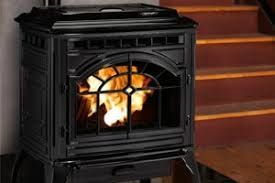 A black wood stove is sitting next to a set of stairs.