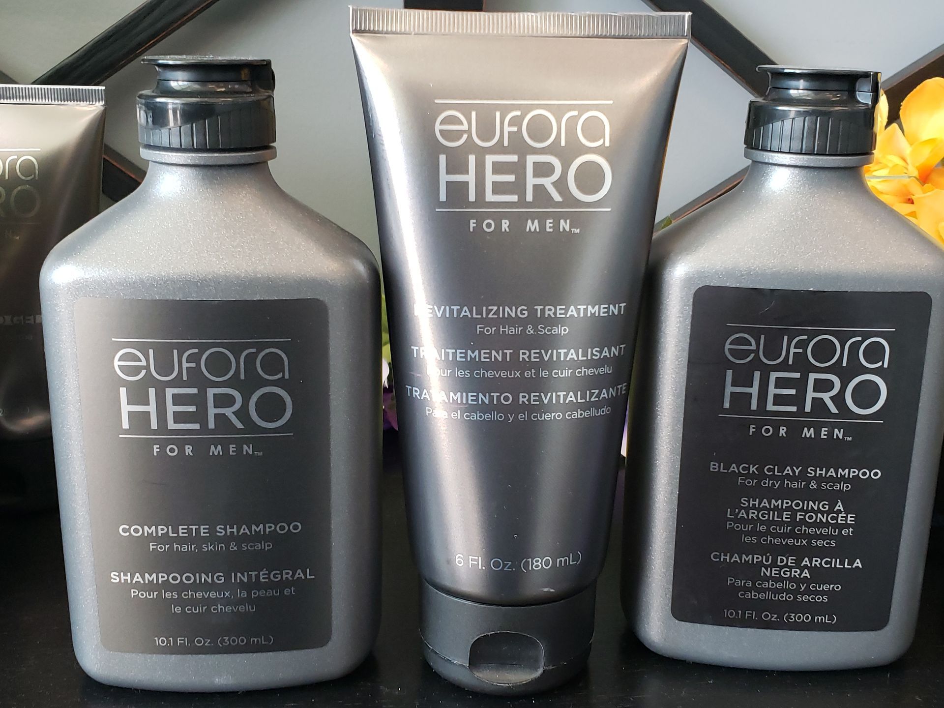 Three bottles of eurora hero for men sit on a table