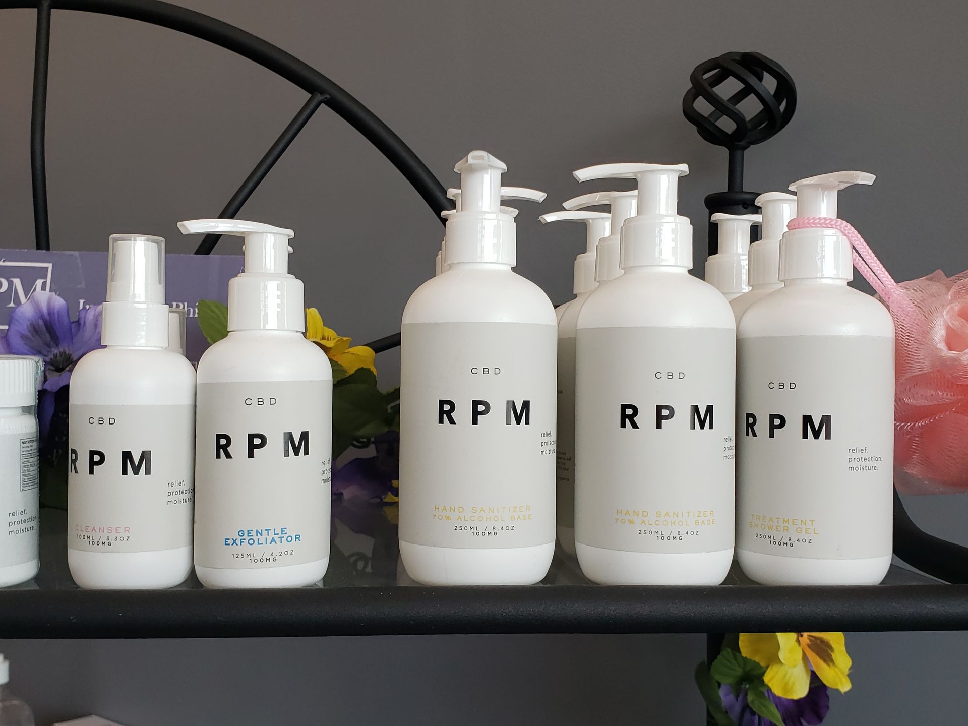 Several bottles of rpm lotion are lined up on a shelf