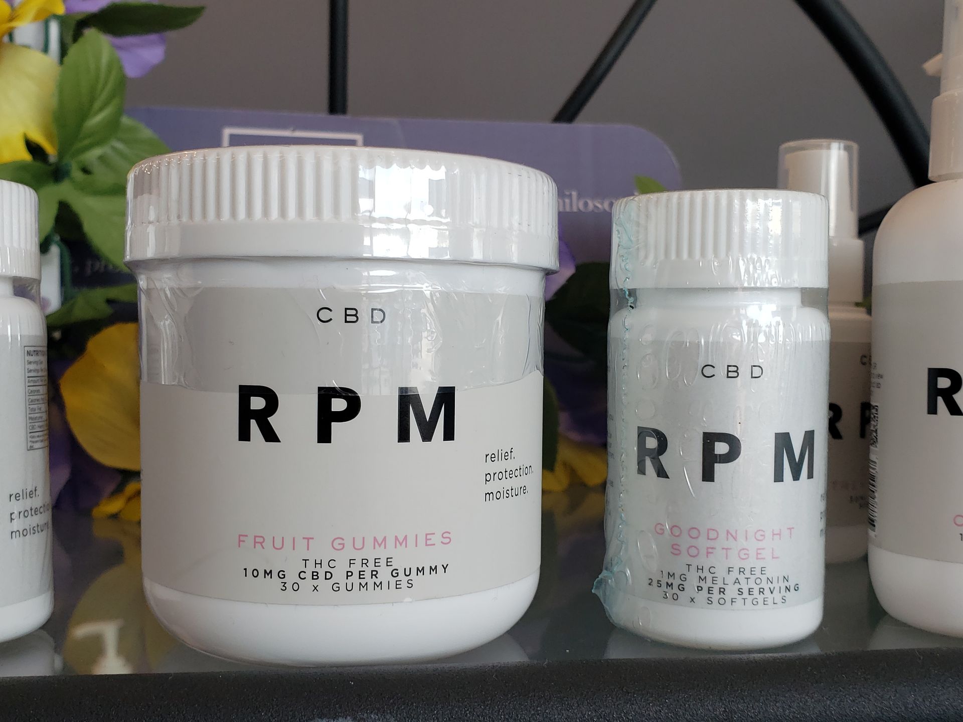 A jar of rpm fruit gummies sits next to a bottle of rpm