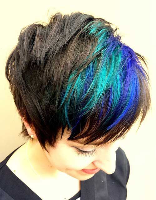 A woman with short hair has blue and green highlights