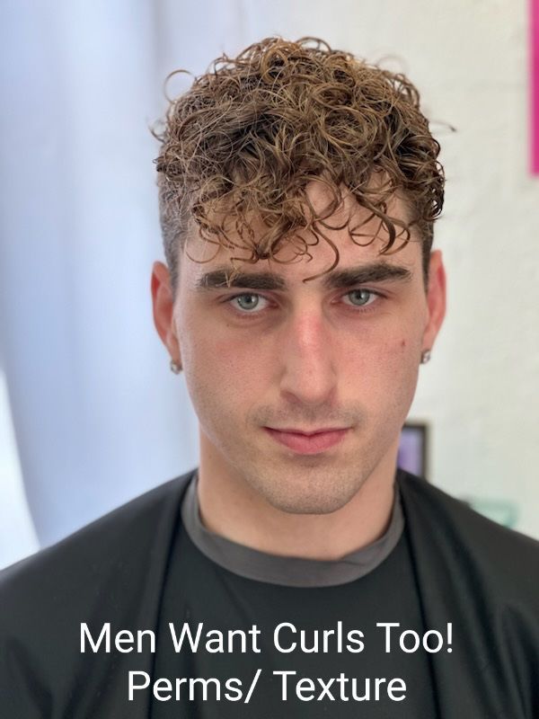 A man with curly hair is wearing a black shirt