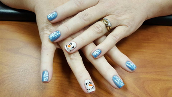 A close up of a person 's nails with a snowman design on them