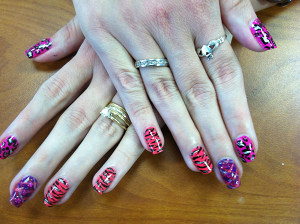 A close up of a woman 's nails with rings on them