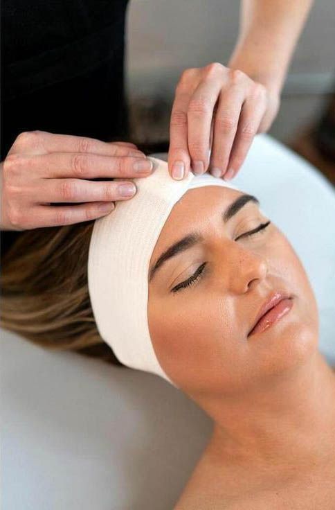 A woman is getting a head massage at a spa.