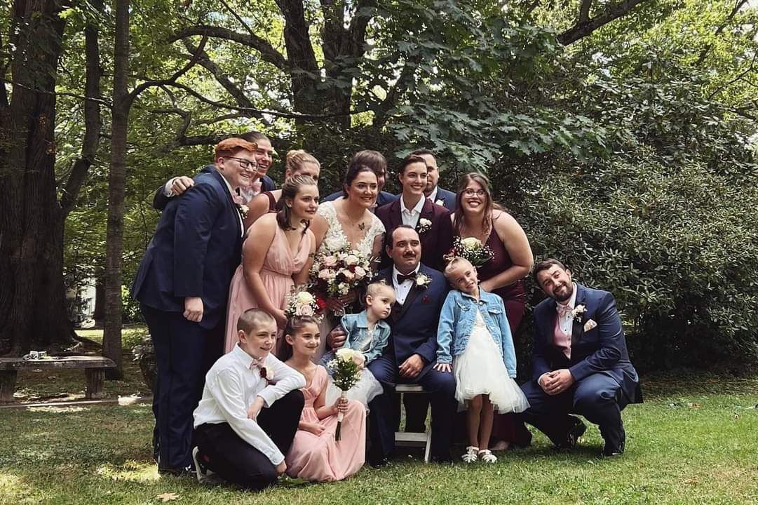 A group of people posing for a picture at a wedding.