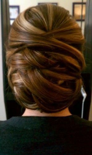 The back of a woman 's head with her hair in a messy bun.