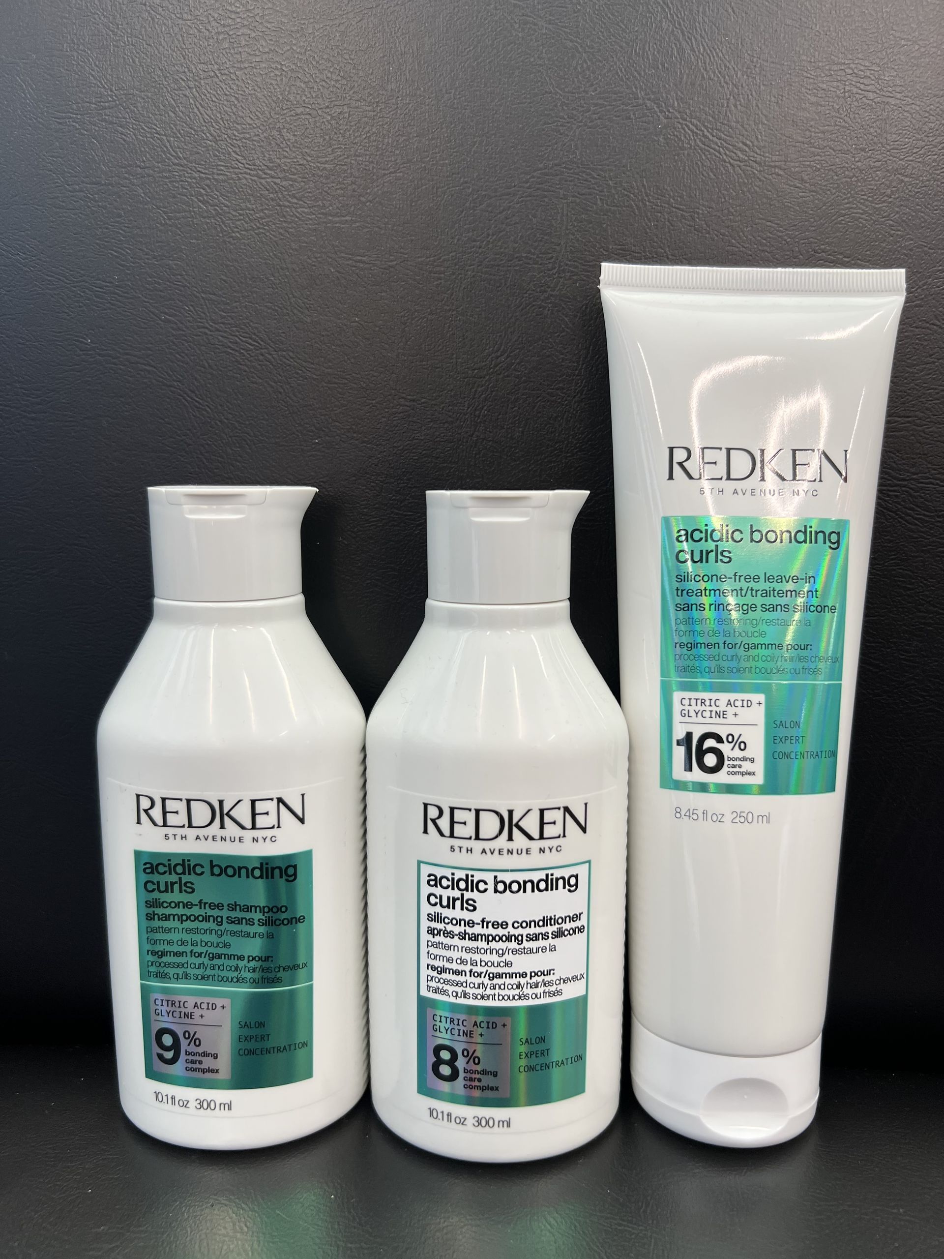 Three bottles of redken hair products on a table