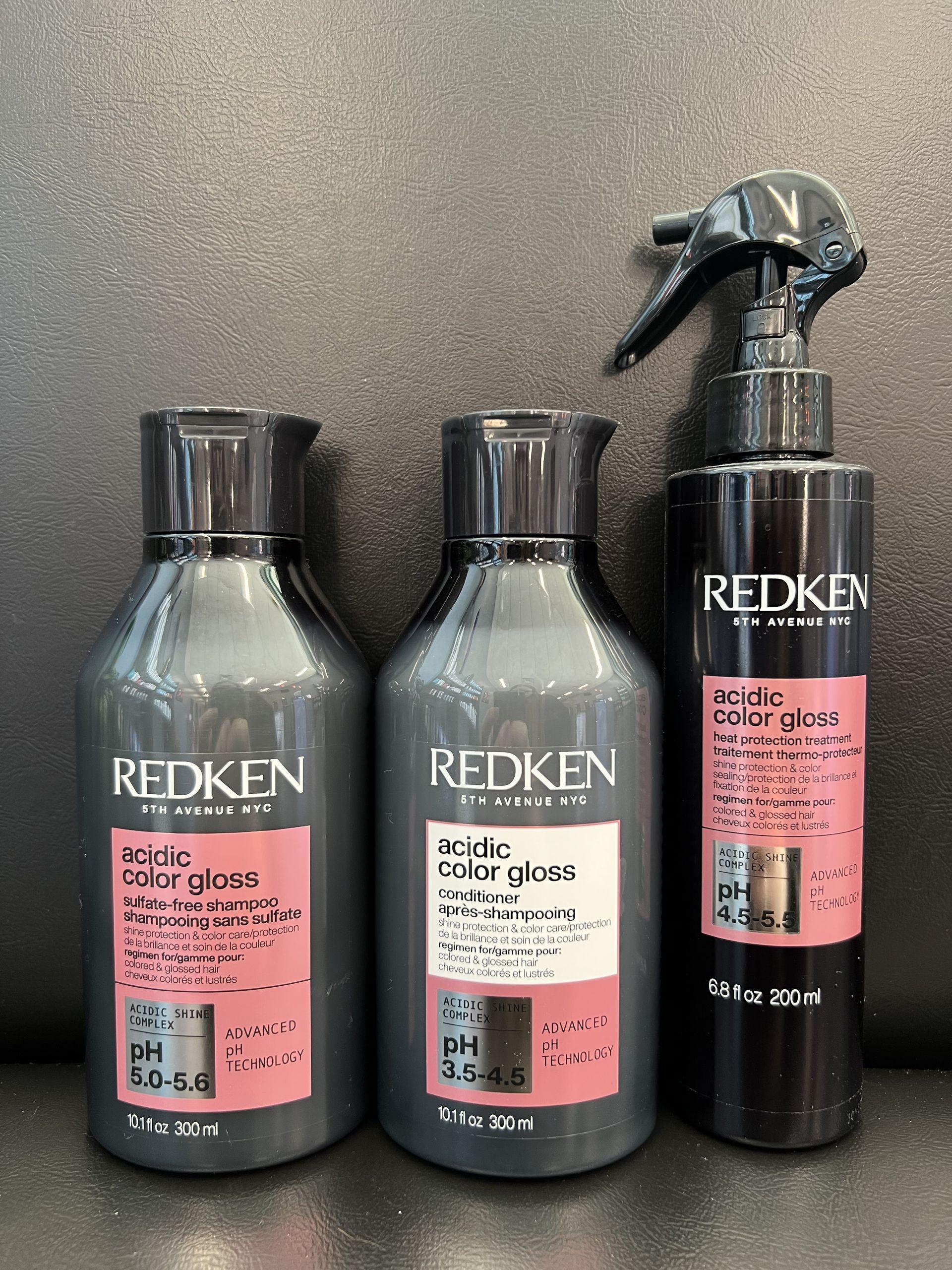Three bottles of redken hair products are sitting on a table.
