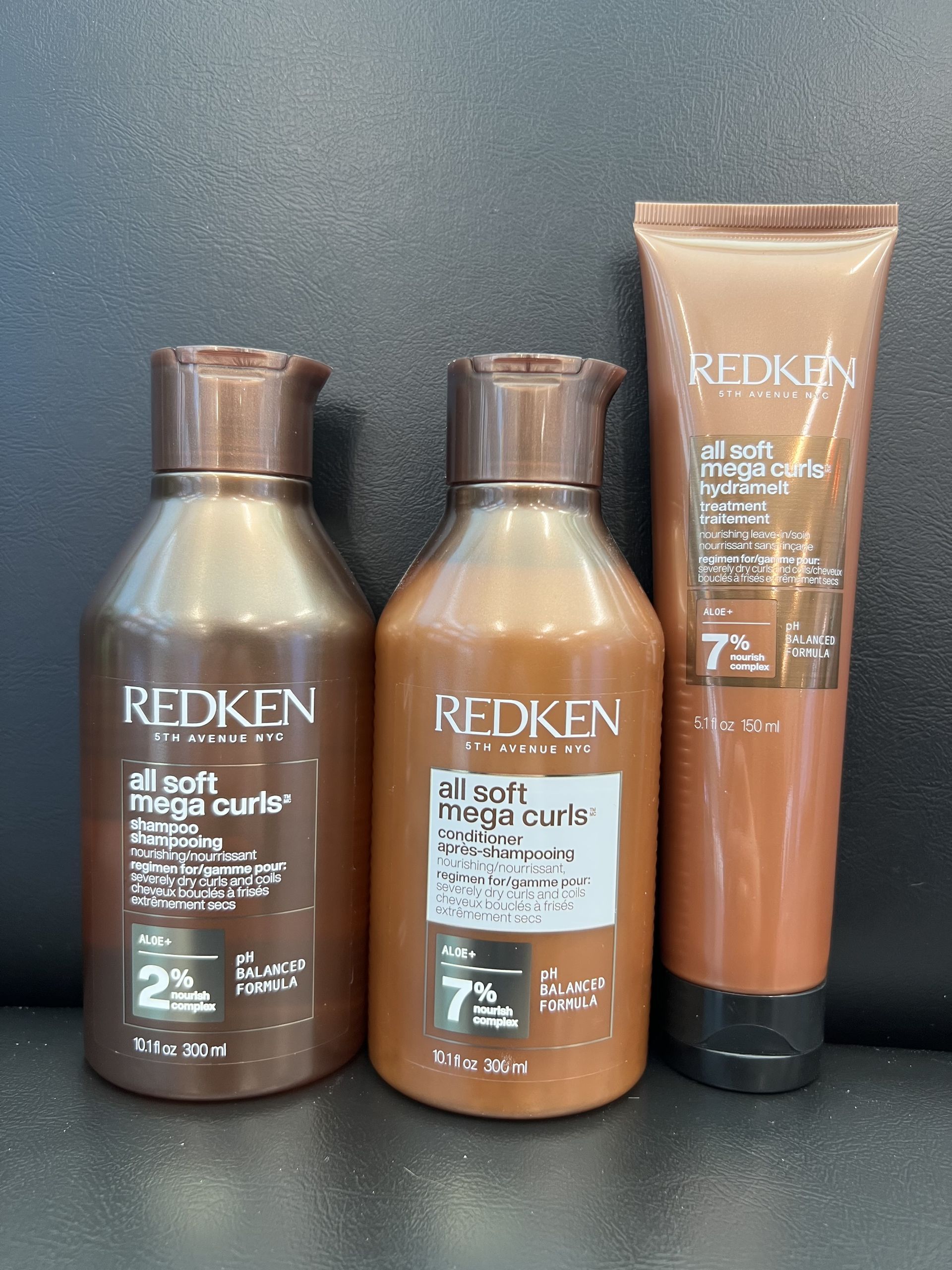 Three bottles of redken hair products are sitting on a table