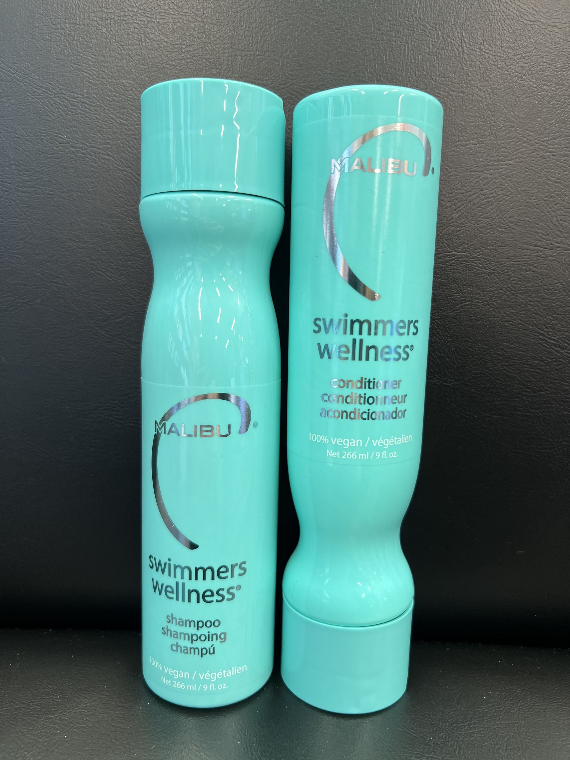 Two bottles of swimmer 's wellness shampoo and conditioner
