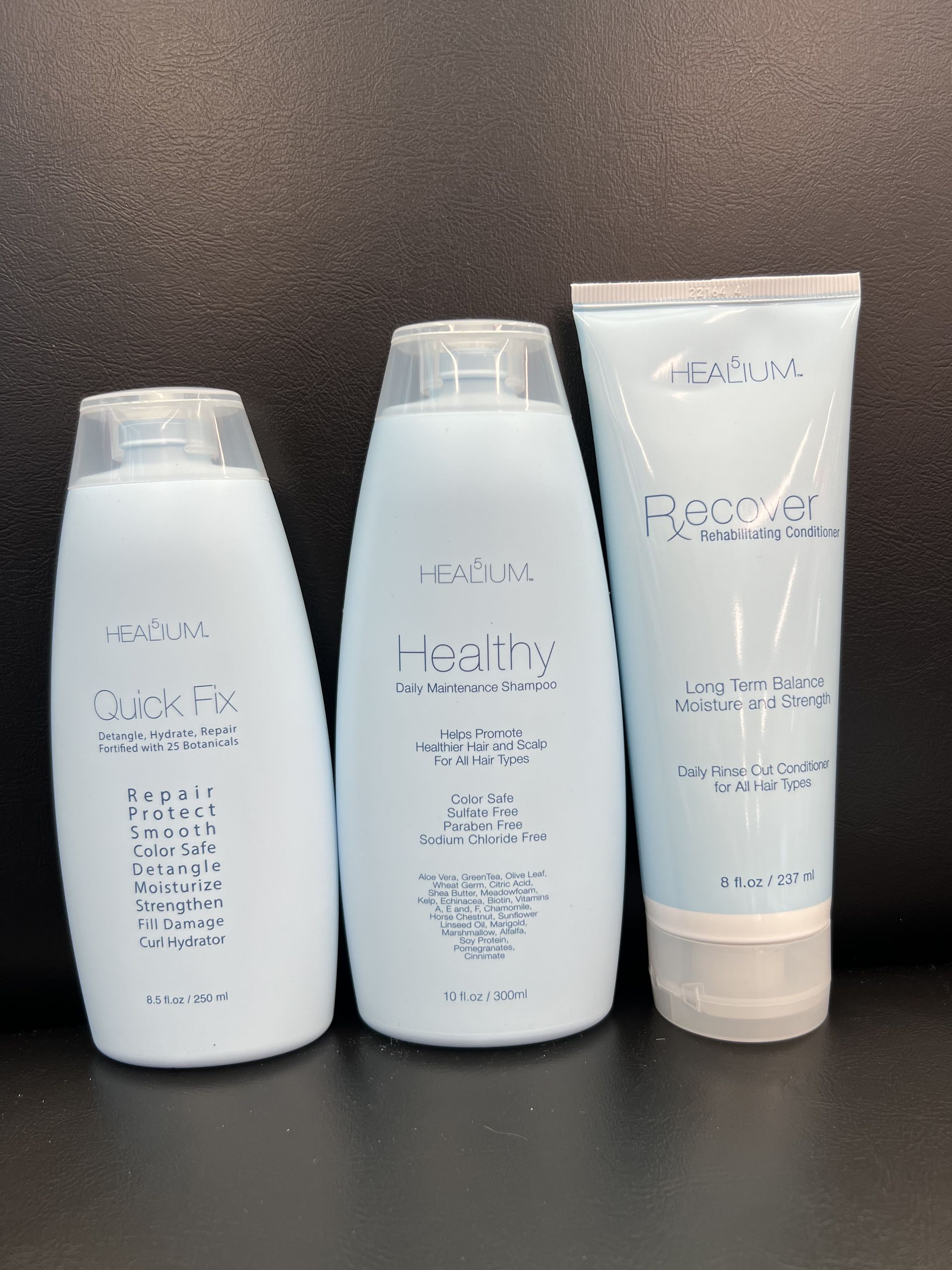 Three bottles of lotion are lined up on a table