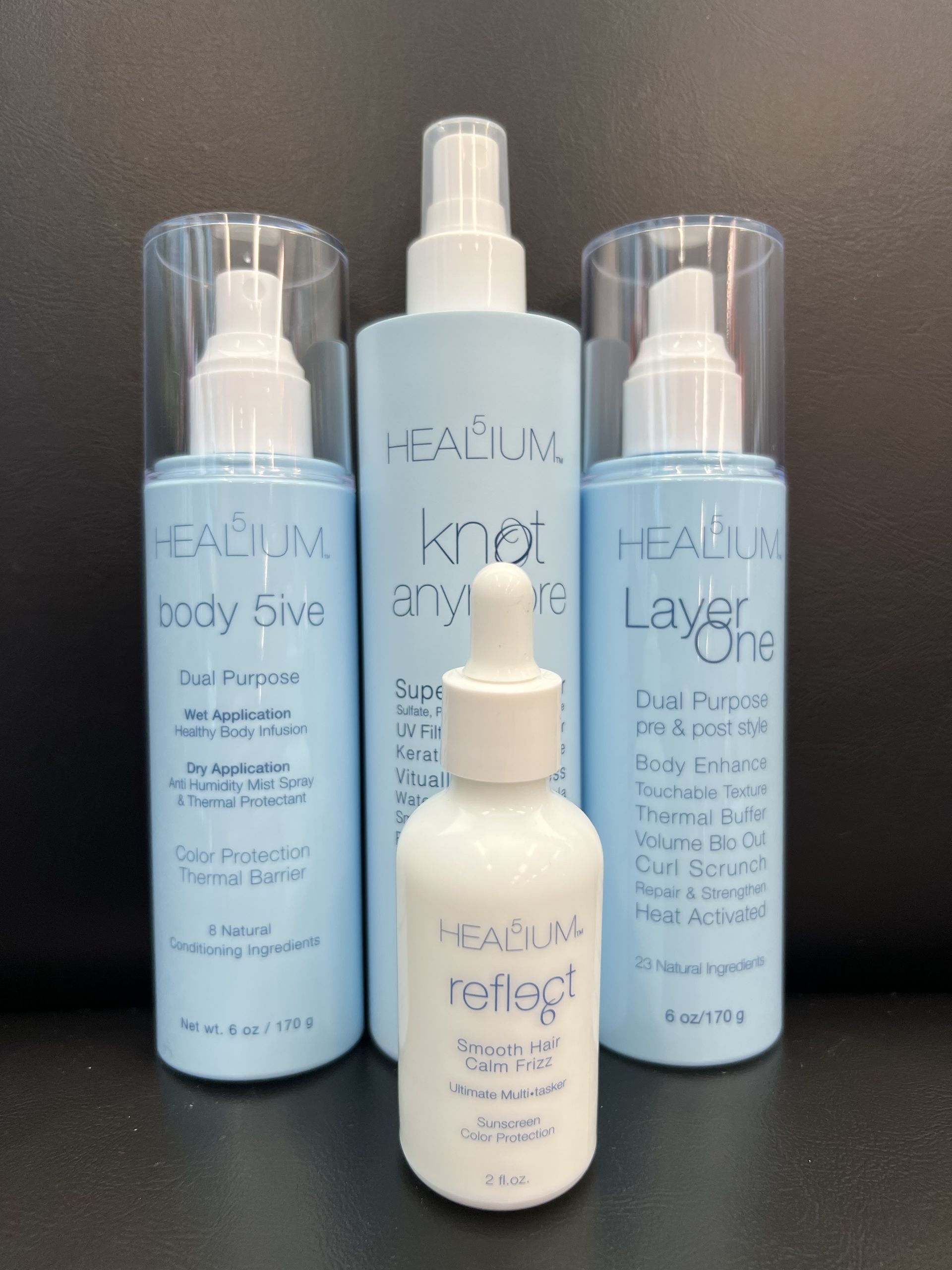 Four bottles of hair products including a serum