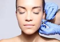 A woman is getting a botox injection in her face.