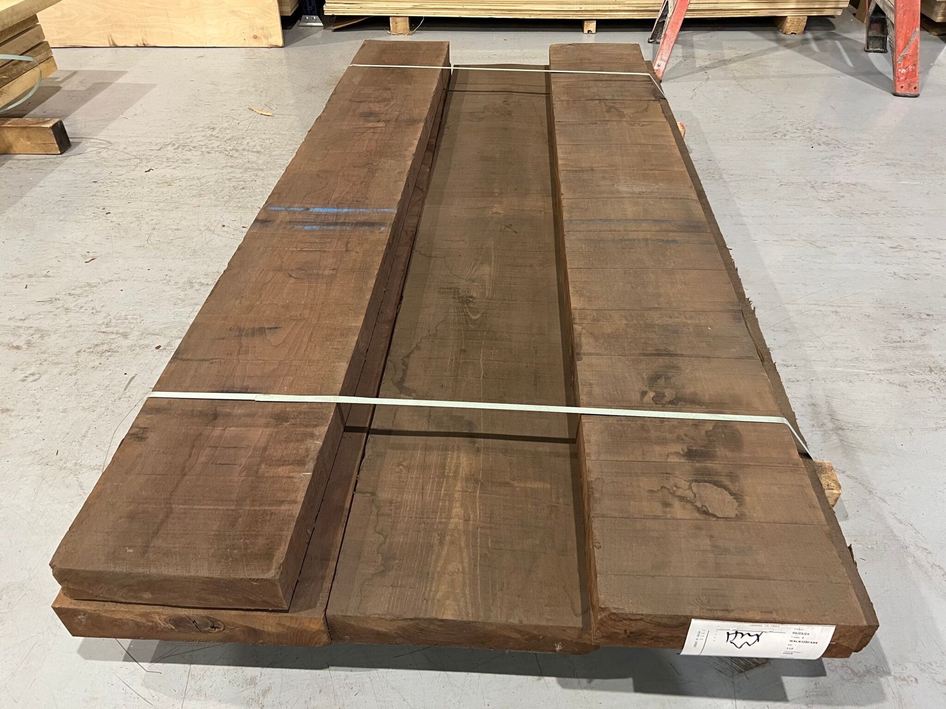 A long piece of wood is sitting on the floor in a warehouse.