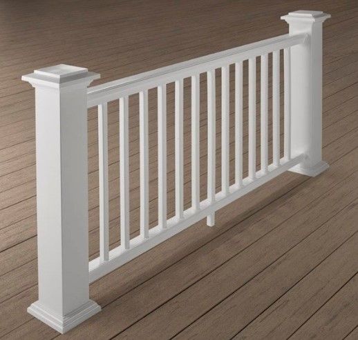 A white railing is sitting on a wooden deck.