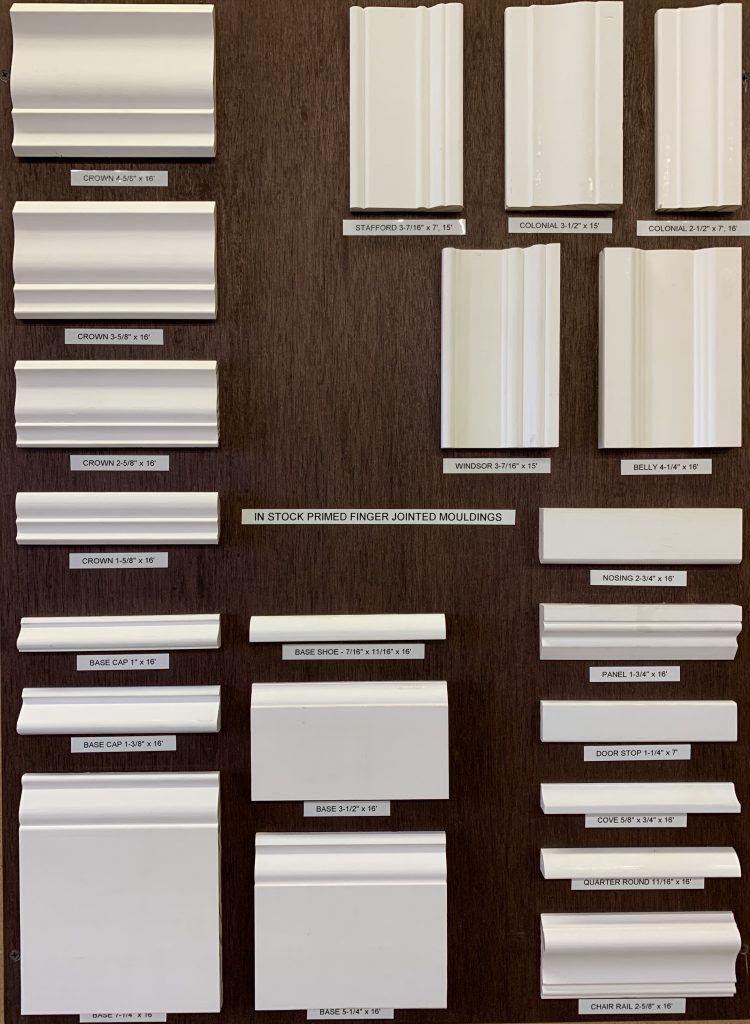 A display of different types of white molding on a wooden surface