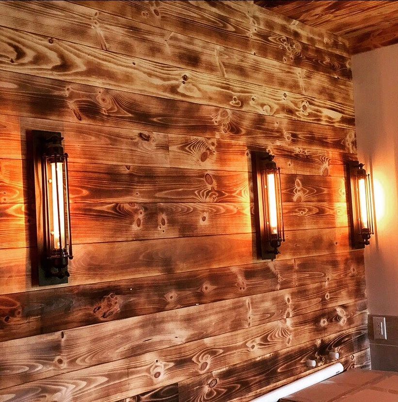 A wooden wall with a row of lights on it