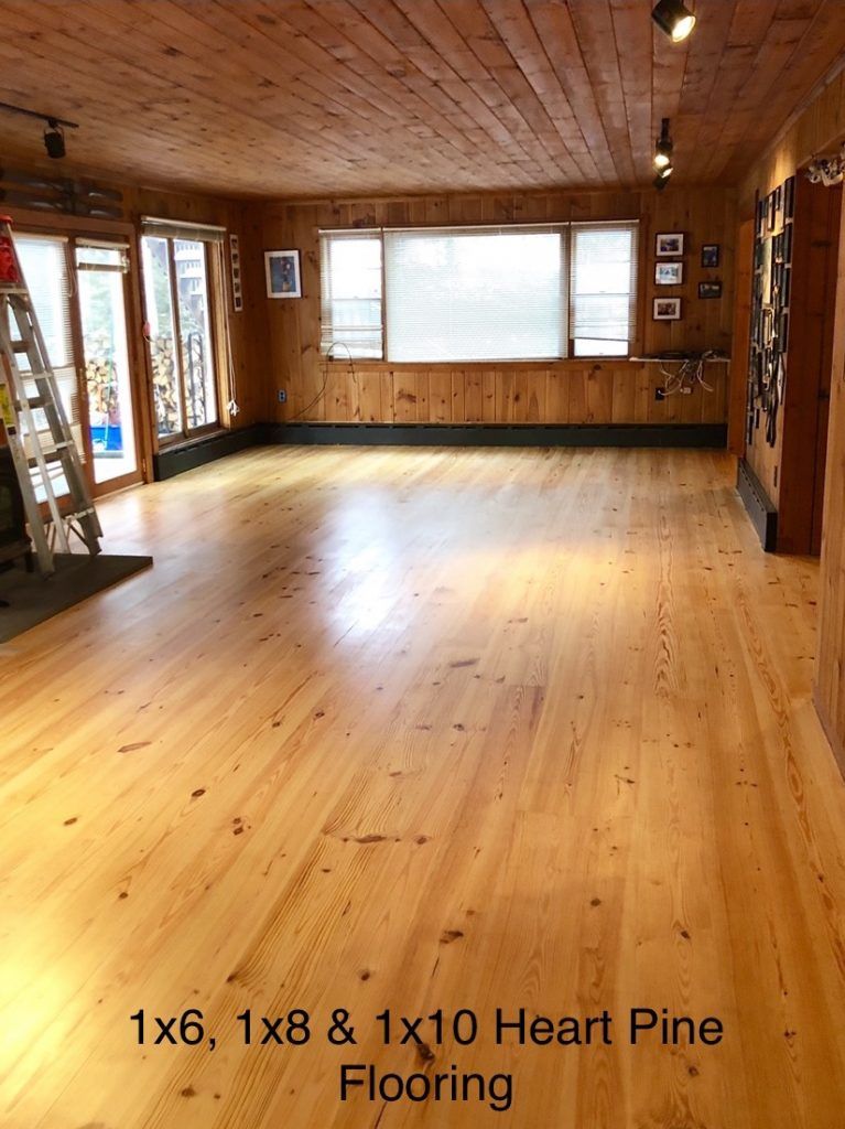 A large room with a wooden floor and a ladder.