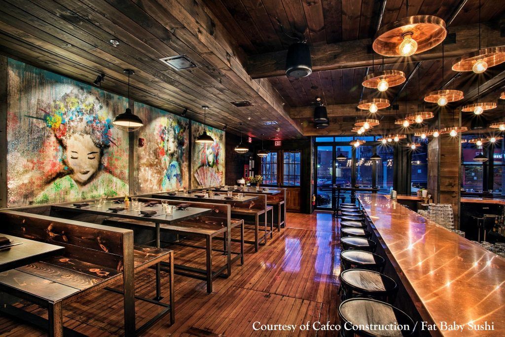 A restaurant with a mural on the wall and a long bar