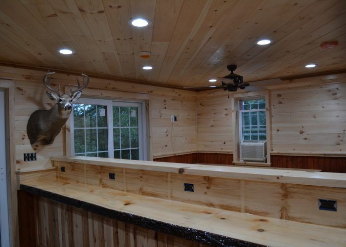A deer head is hanging from the ceiling of a wooden room.