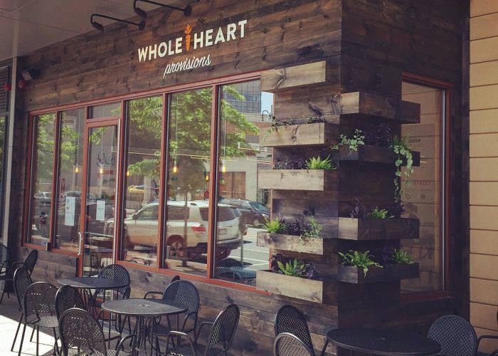 A restaurant with tables and chairs outside of it.