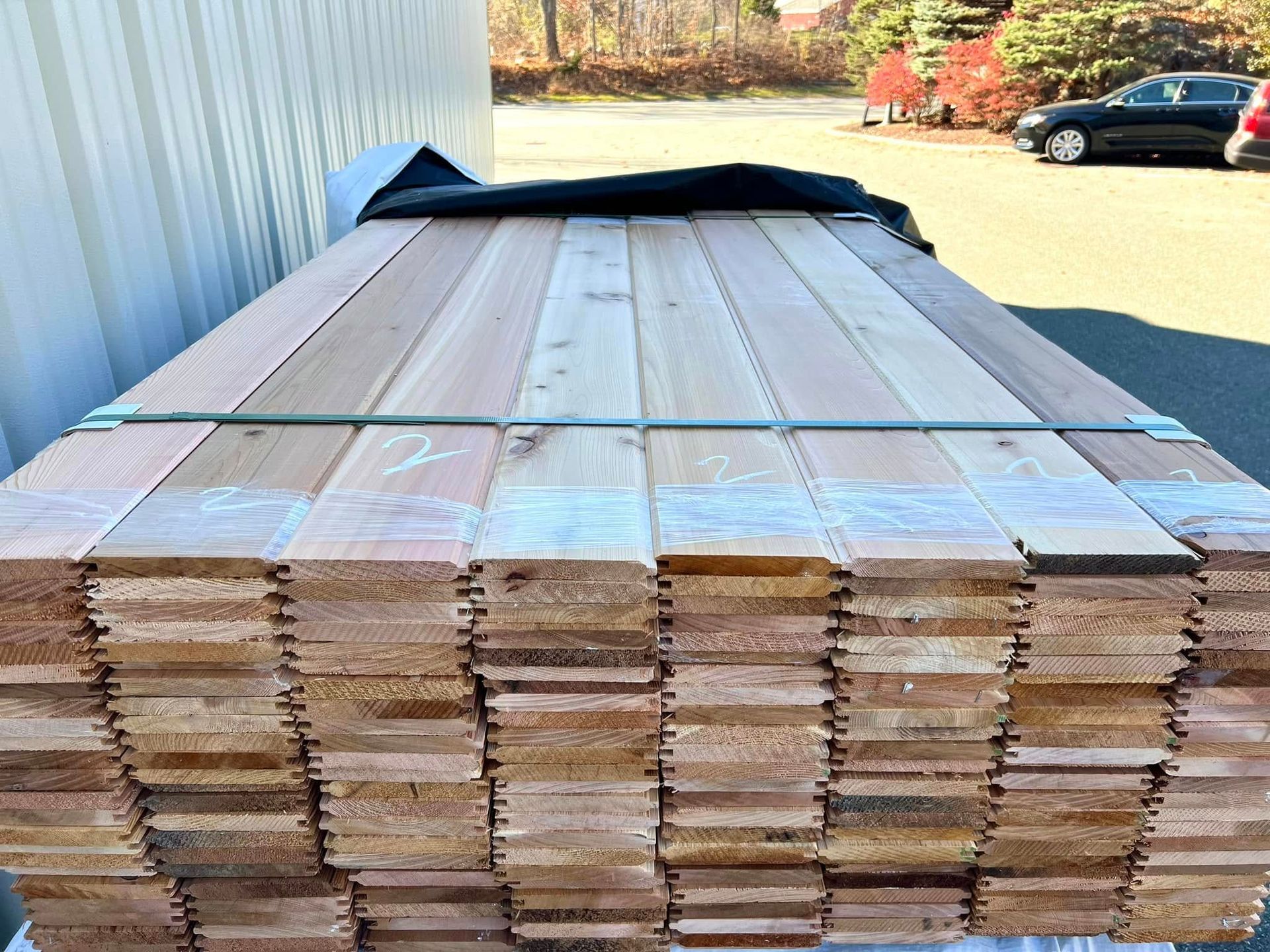 A stack of wooden planks sitting on top of each other in a parking lot.