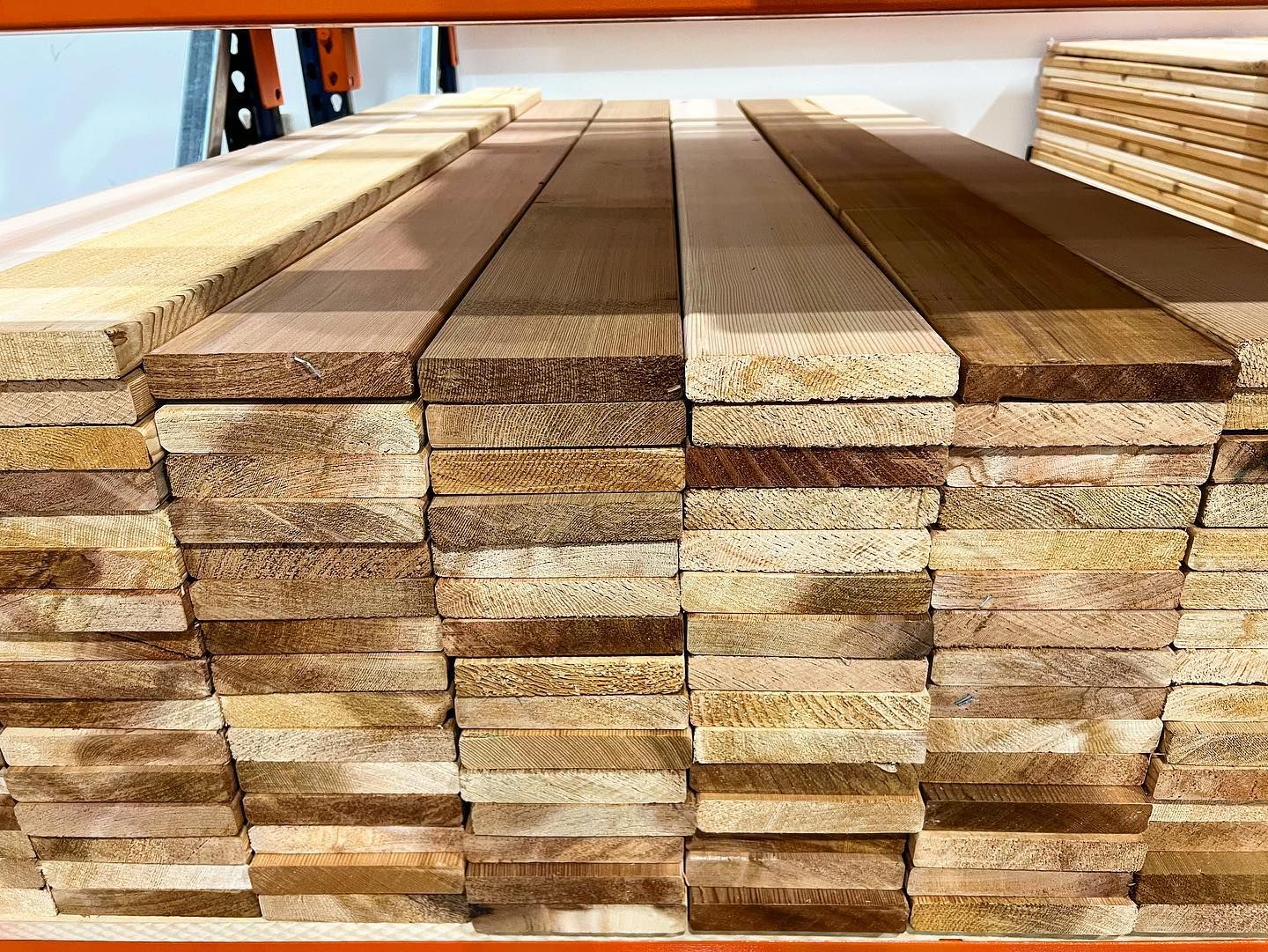 A stack of wooden boards sitting on top of each other on a shelf.