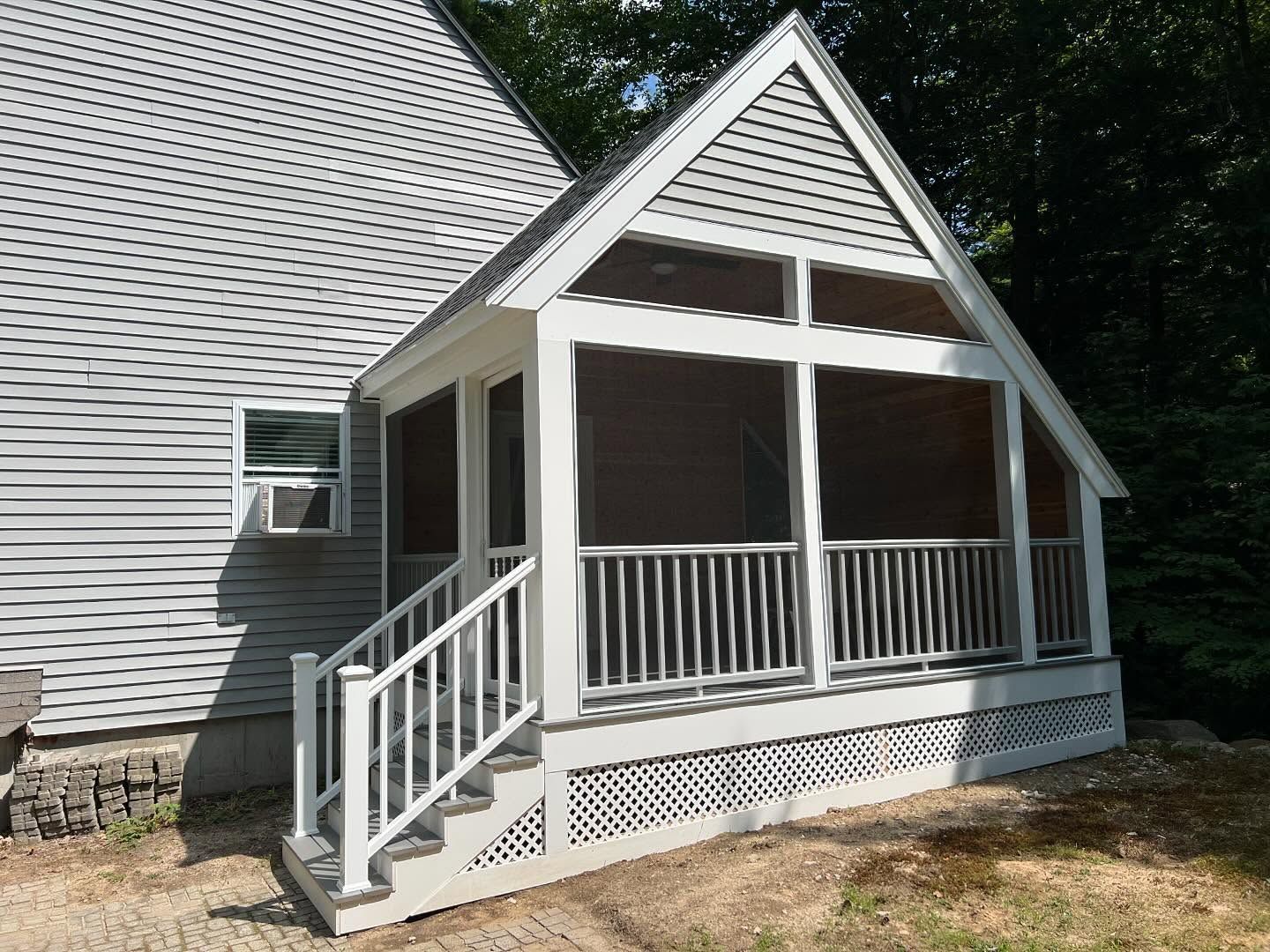 A screened in porch on the side of a house