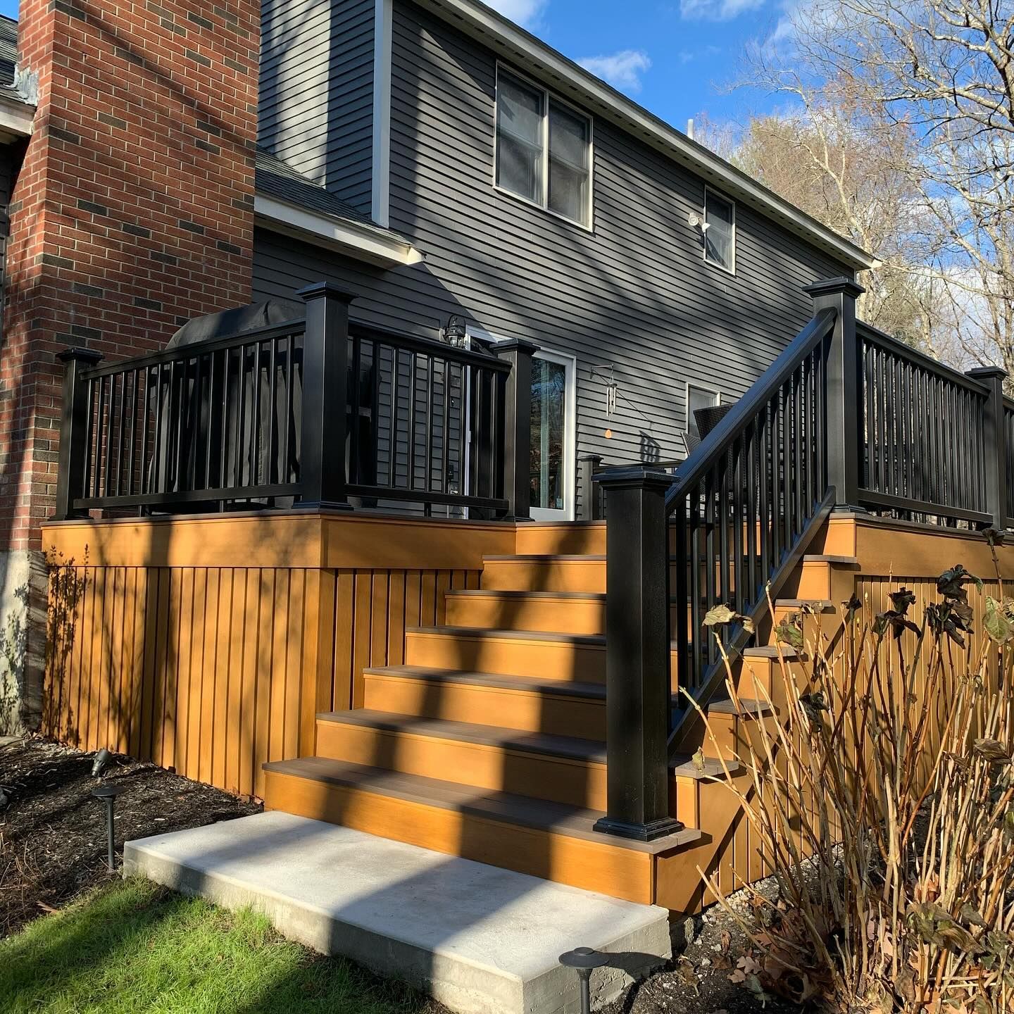 A house with a wooden deck and stairs in front of it.