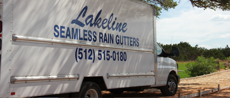 White truck with “Lakeline Seamless Rain Gutters” business logo and phone number on the side, parked outdoors.
