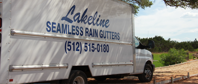White truck with “Lakeline Seamless Rain Gutters” logo parked at a construction site.