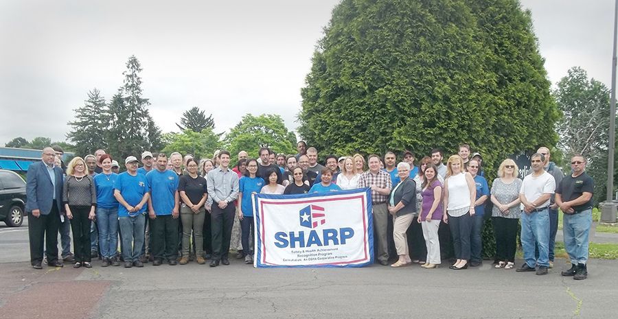 a large group of people standing in front of a sharp sign .