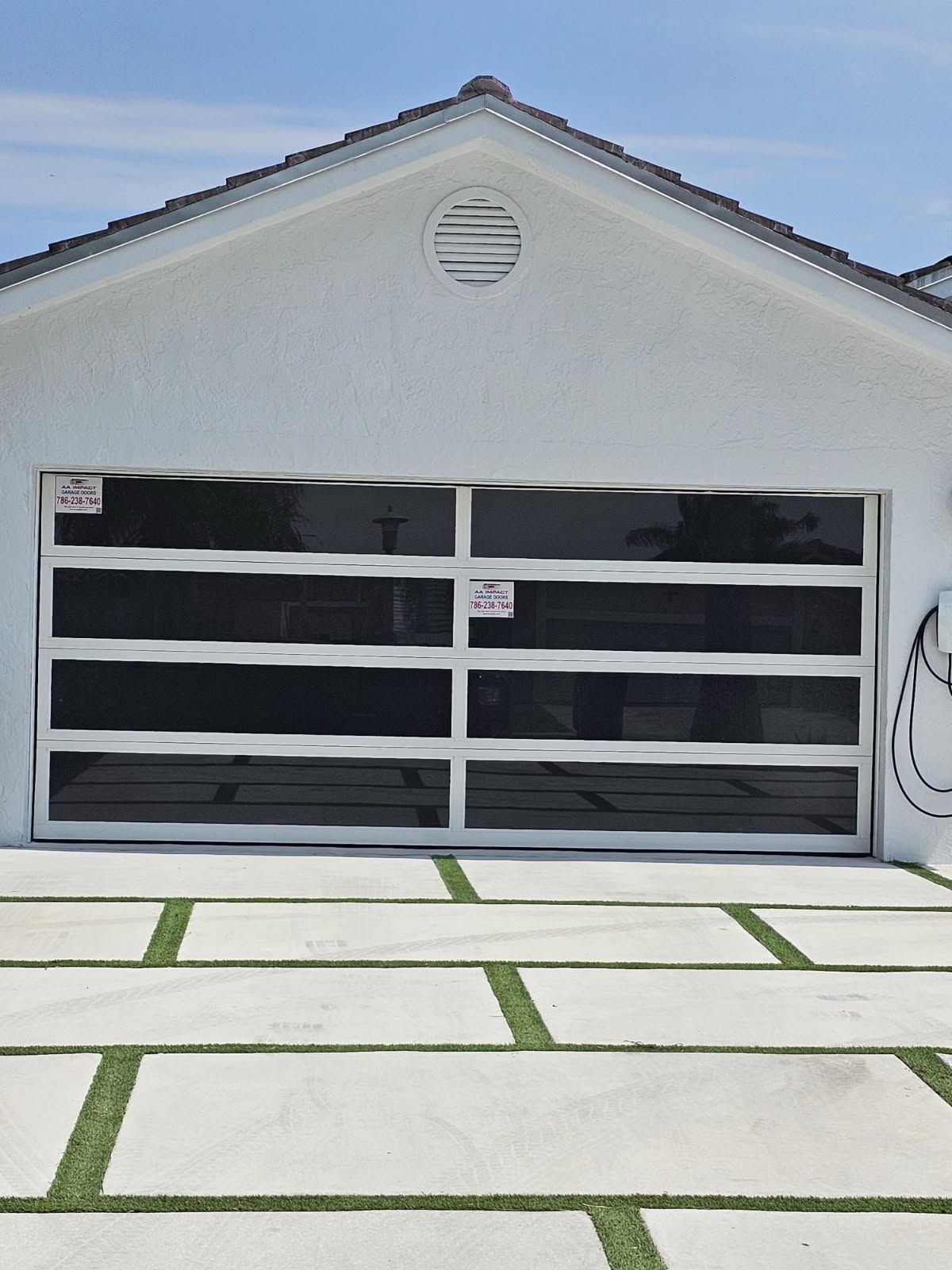 A white house with a large glass garage door