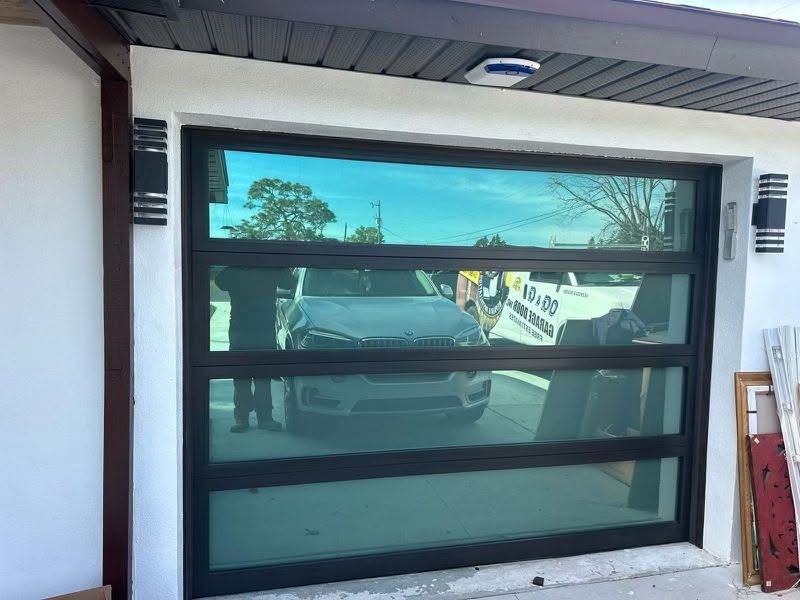 A car is parked in a garage with a glass door.