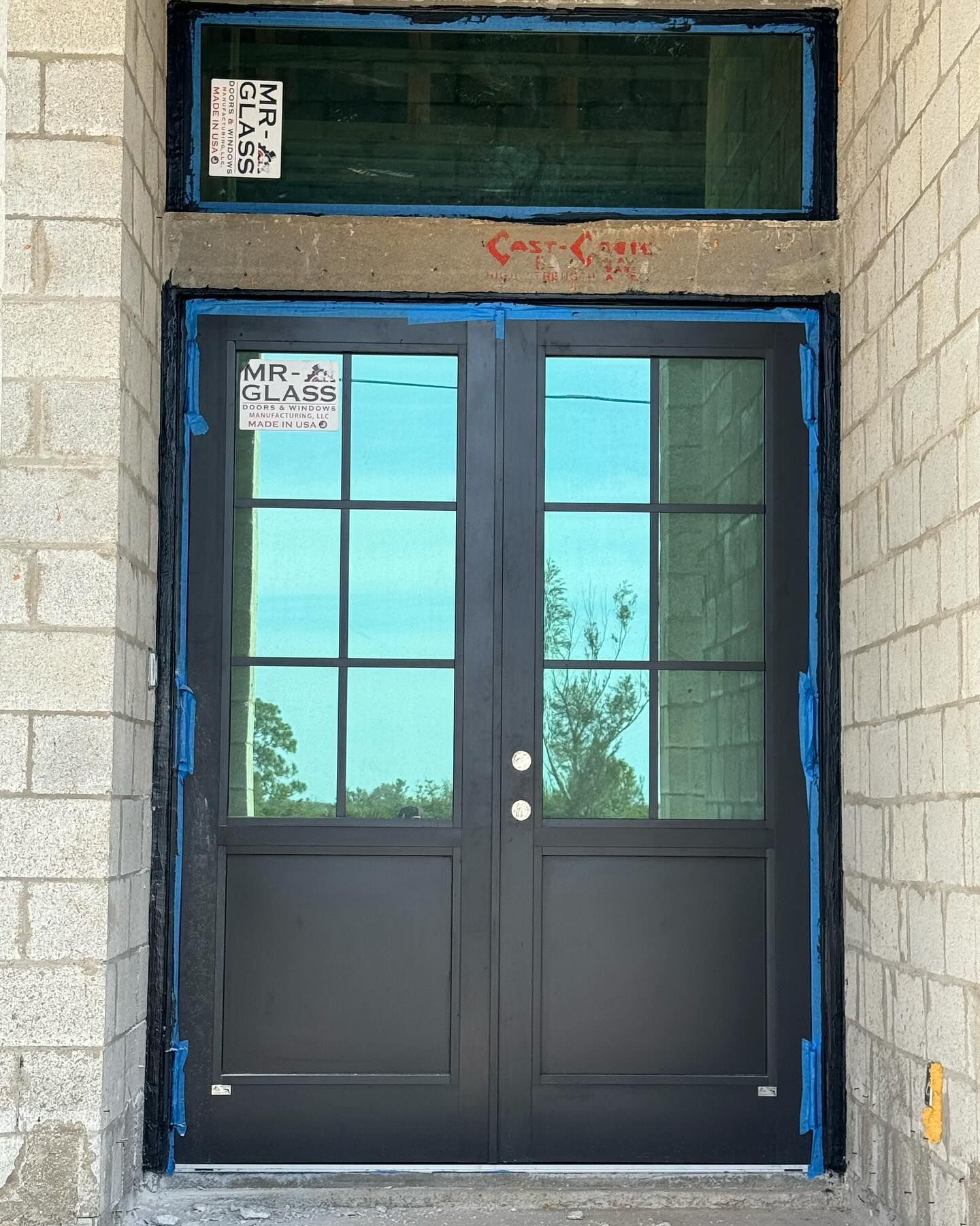 A black door with a sticker on it that says mr glass
