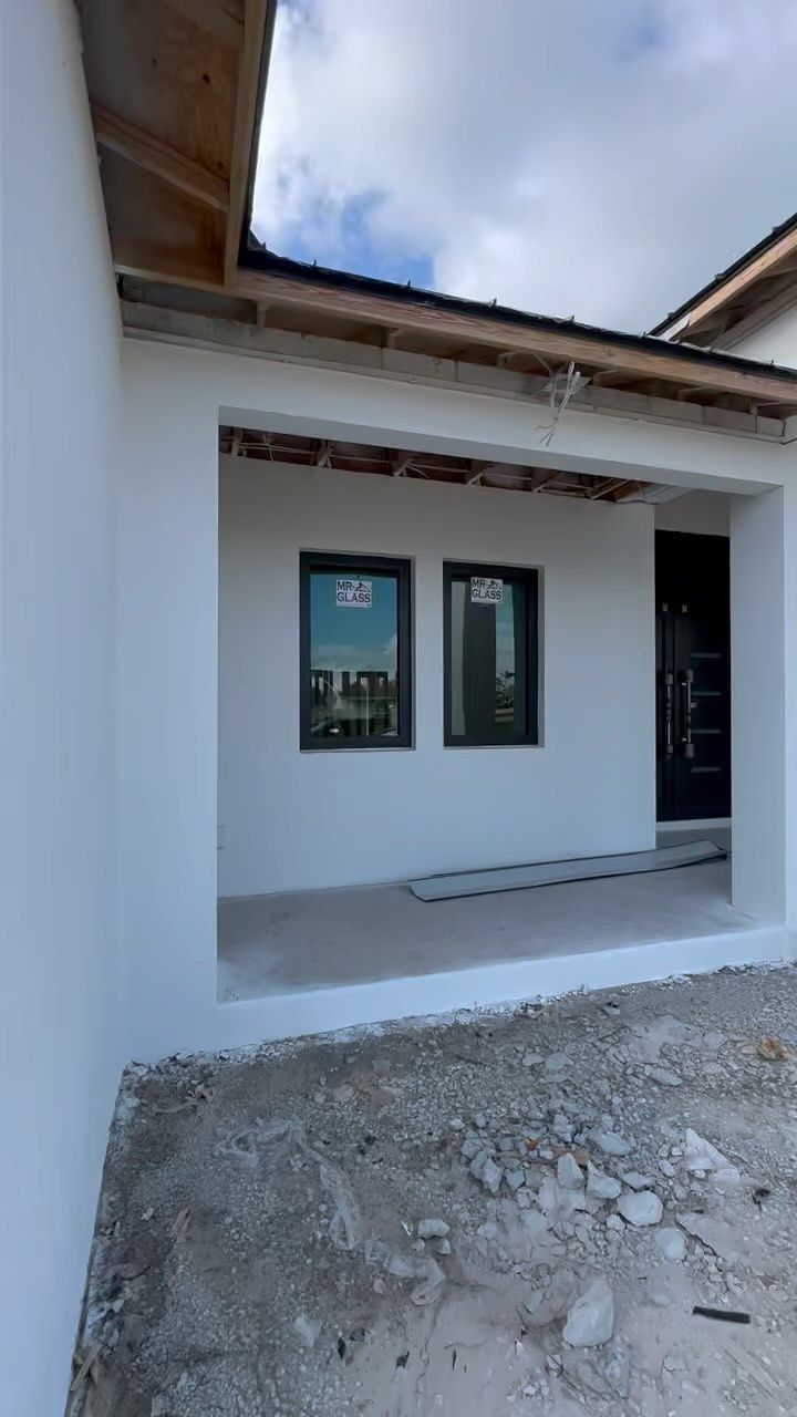 A white house with black windows is being built.
