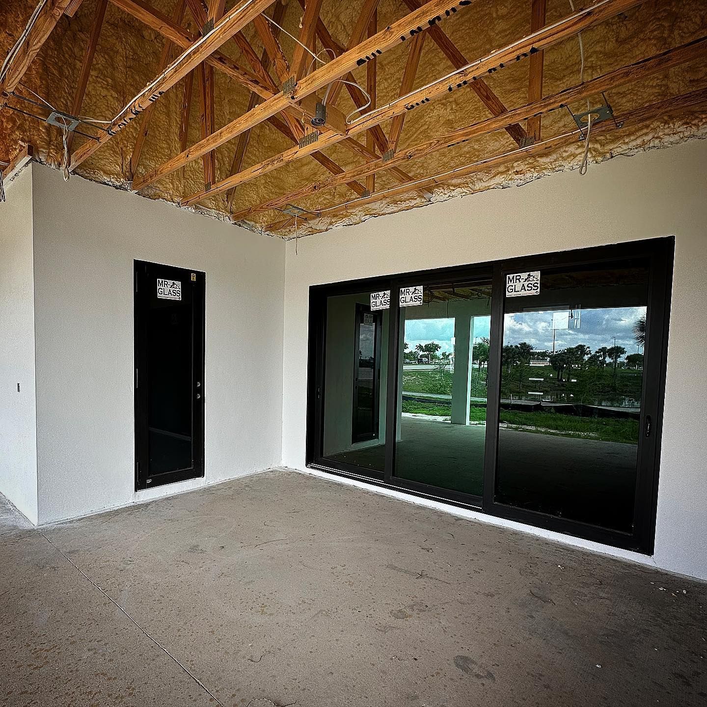 An empty room with sliding glass doors and a wooden ceiling