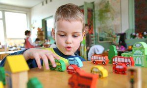 Pre-kindergarten boy playing with toy cars