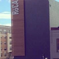 Exterior of a building with a vertical “BGA” sign and a large purple wall panel