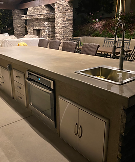 A kitchen with a sink , oven , drawers and cabinets