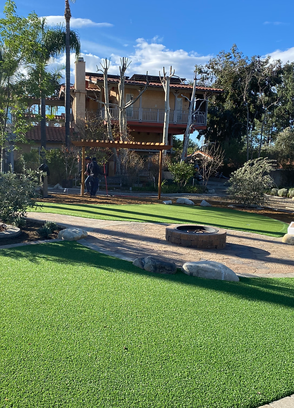 There is a large house in the background and a large lawn in the foreground.