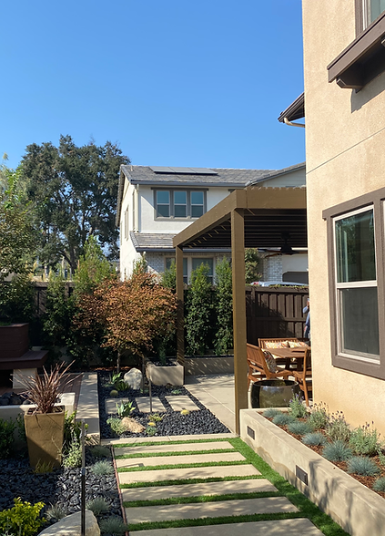 A house with a pergola and a walkway leading to it.