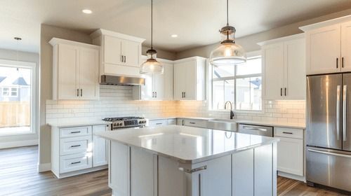 Bright modern kitchen with white cabinets, stainless steel appliances, and a large central island