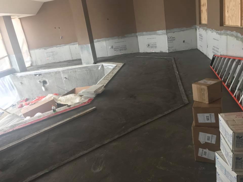 A ladder is sitting in a room next to a bathtub.