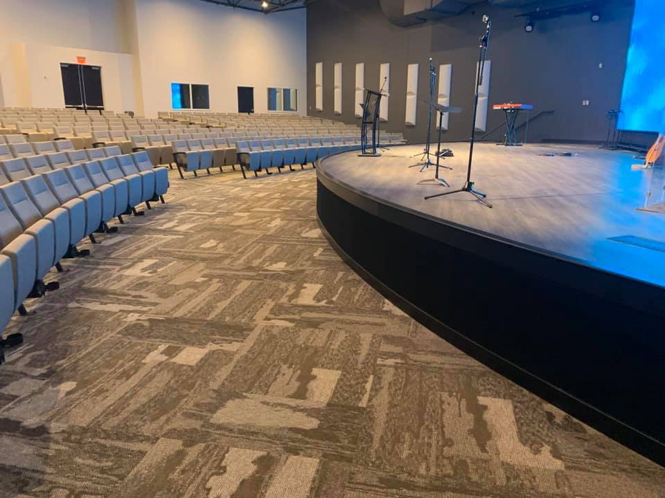 A large auditorium with rows of seats and a curved stage.