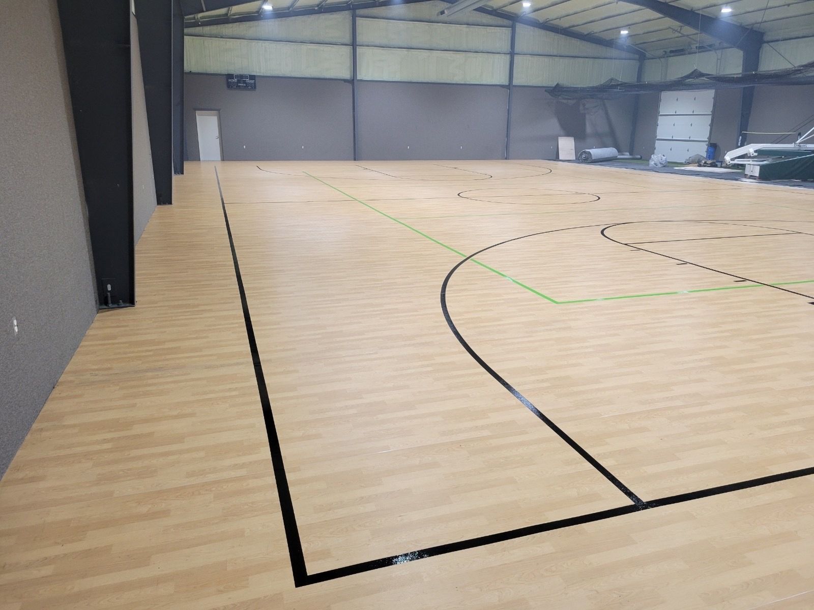A large indoor basketball court with a wooden floor