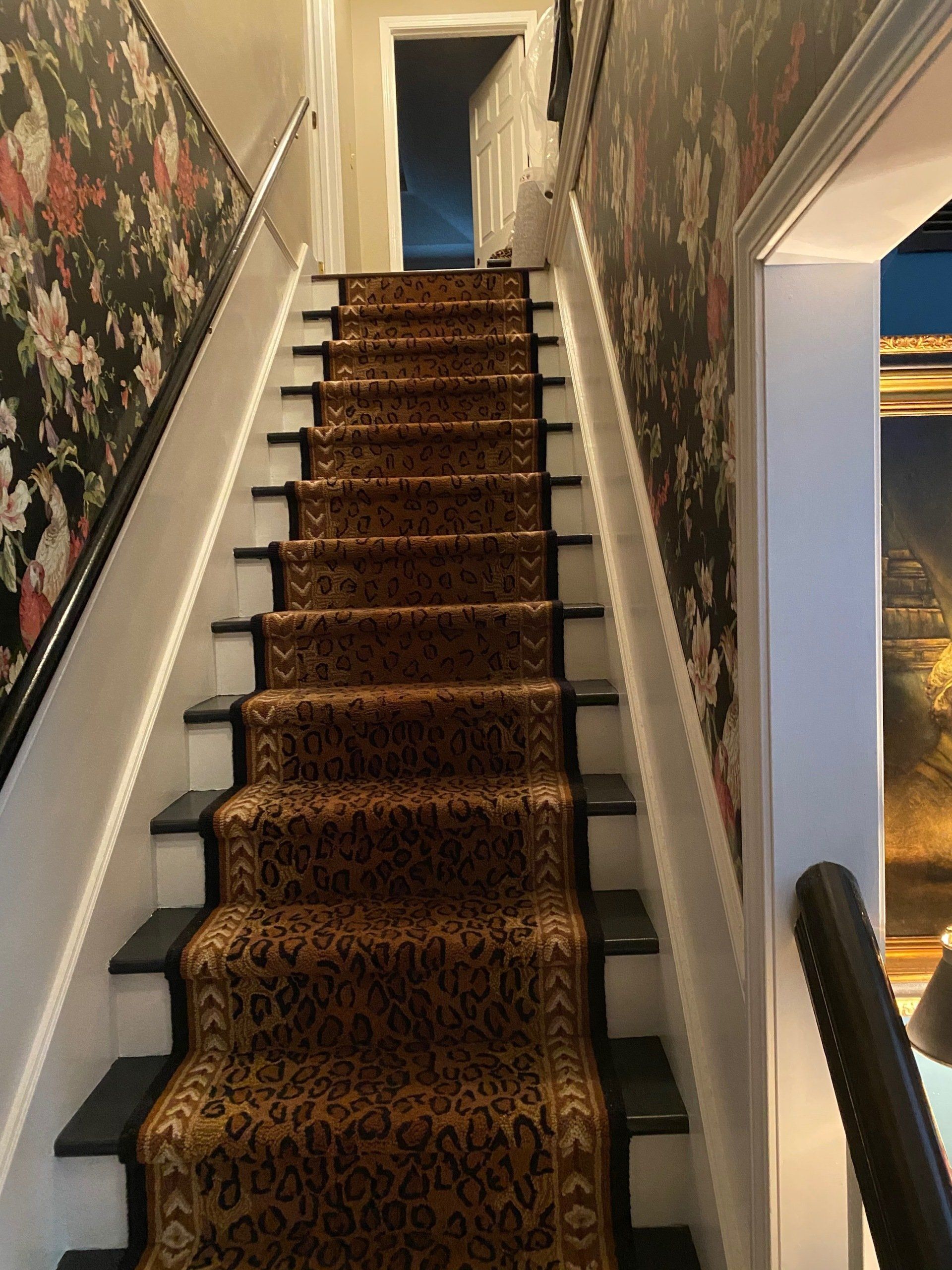 A set of stairs with a floral wallpaper on the wall